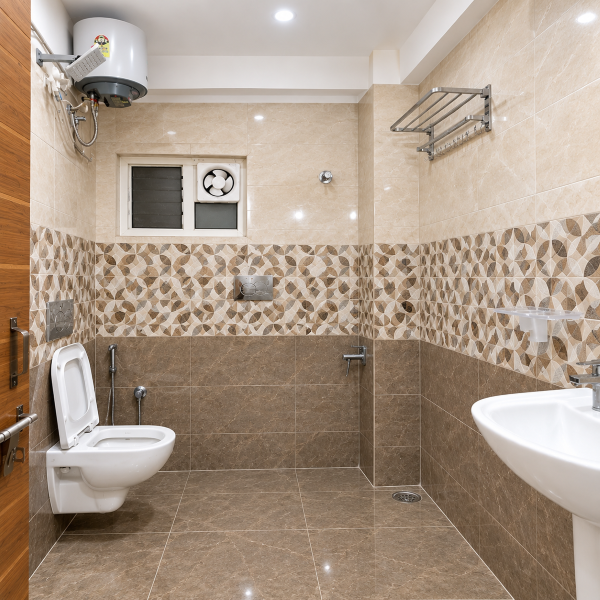 Modern bathroom, contemporary bathroom, beige bathroom, tiled bathroom, bathroom interior, Indian bathroom design, residential bathroom, wall tiles, patterned wall tiles, geometric tiles, hexagon tiles, beige marble tiles, floor tiles, ceramic tiles, porcelain tiles, toilet design, western toilet, wall mounted toilet, bathroom ventilation, exhaust fan, bathroom window, water heater, geyser, shower area, handheld shower, bathroom faucet, wash basin, pedestal sink, bathroom fixtures, sanitary ware, towel rack, stainless steel rack, bathroom storage, utility bathroom, compact bathroom, spacious bathroom, clean bathroom, neutral bathroom, warm beige tones, marble effect tiles, decorative tiles, accent tile wall, bathroom renovation, modern sanitaryware, bathroom decor, functional bathroom, minimalist bathroom, Indian home bathroom, apartment bathroom, house bathroom, tiled walls, tiled floor, plumbing fixtures, wall mounted accessories, ventilation window, bathroom lighting, ceiling light, bright bathroom, hygienic bathroom, practical design, contemporary sanitaryware, toilet room, bathroom layout, residential interior, home improvement, bathroom remodeling, modern home design, beige interior, stone texture, geometric pattern, patterned backsplash, floor drain, bathroom door, wooden bathroom door, utility fittings, water heater installation, exhaust ventilation, compact washroom, modern washroom, clean tile design, neutral palette, simple bathroom, elegant bathroom, functional interior, durable tiles, easy maintenance bathroom, bathroom inspiration, interior design ideas, Indian interior decor, home renovation ideas, contemporary home, modern house, bathroom styling, bathroom fixtures design, tiled washroom, residential washroom, premium bathroom design, practical home interiors, bathroom photography, modern toilet room.